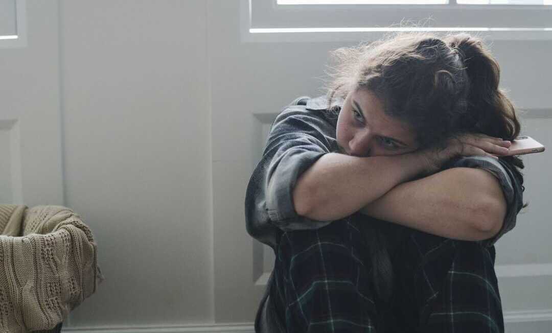 Girl sitting alone and sad in her room